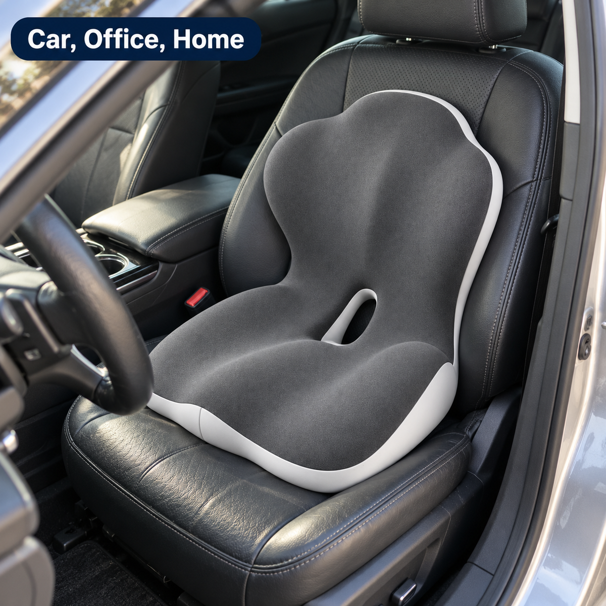 The 2-in-1 cushion sitting in the driver's seat of a car with black leather seats, its back piece filling the space behind the lower back.