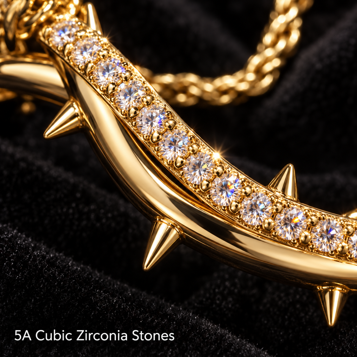 Macro close-up of the gold pendant showing its row of sparkling clear CZ stones and small thorn spikes.