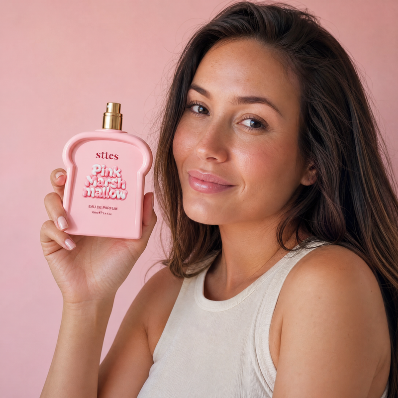 A woman holds the pink marshmallow perfume bottle in one hand to show its size.